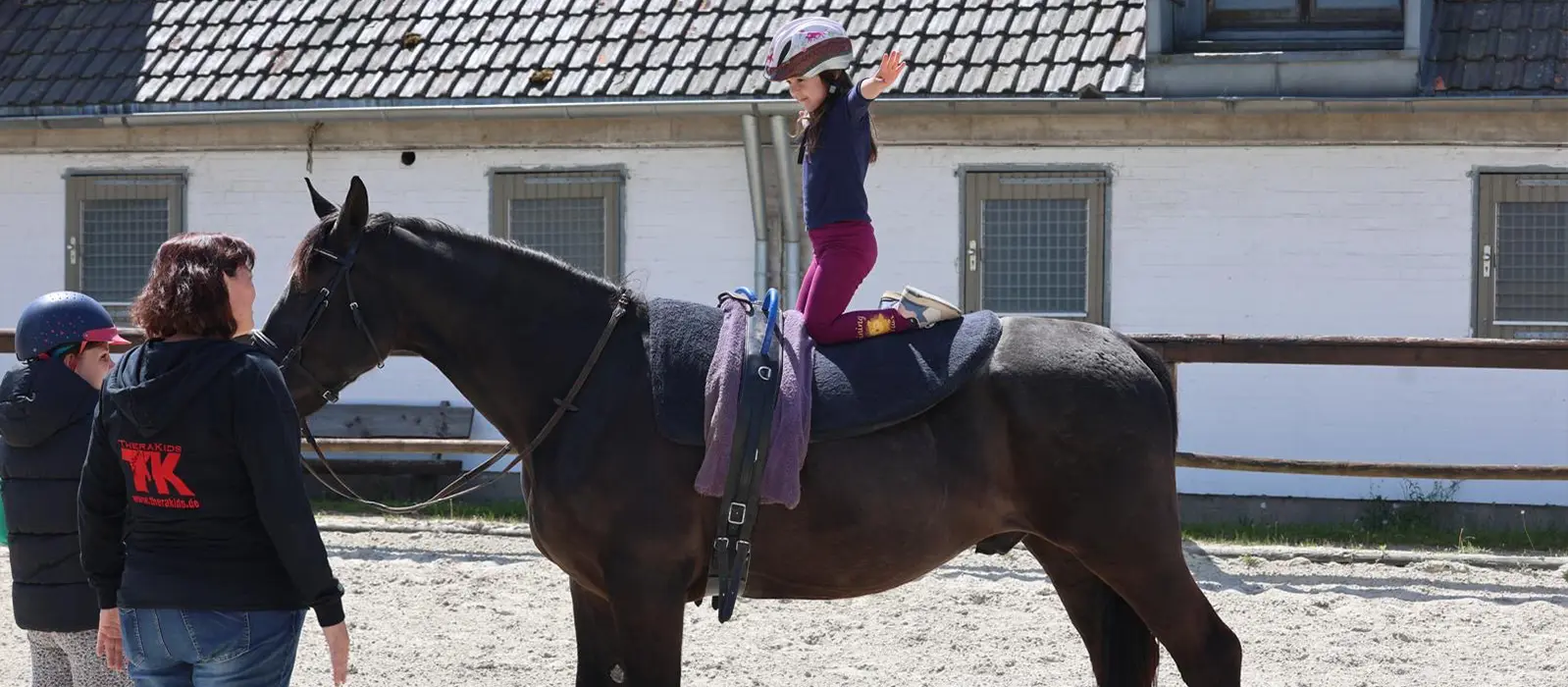 Mädchen macht Akrobatische Kunststücke auf Pferd